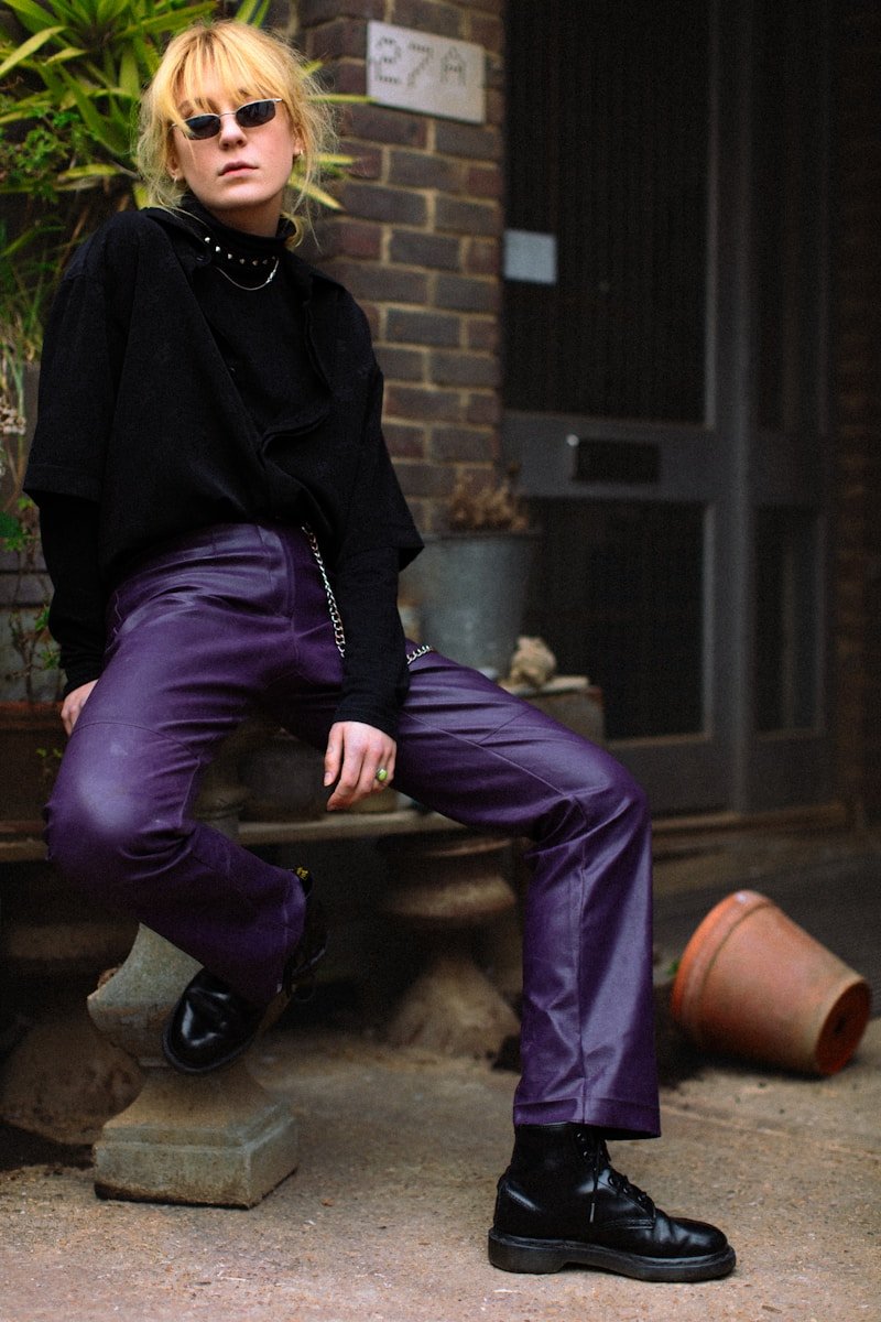 Stylish woman in purple pants posing outdoors
