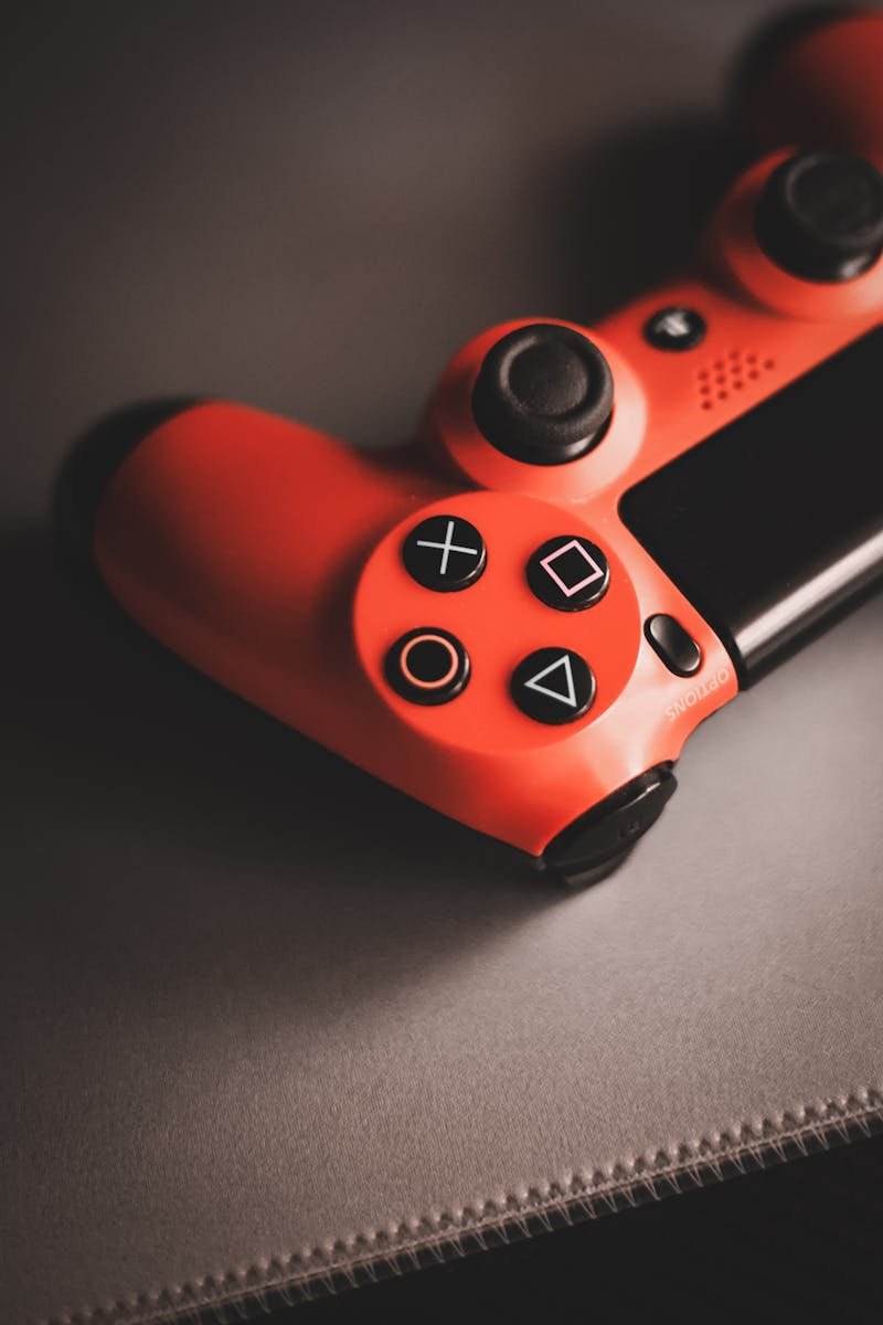 Red vintage game controller on a surface, showcasing nostalgic gaming design.
