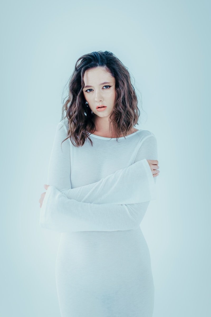 Woman in white dress with arms crossed